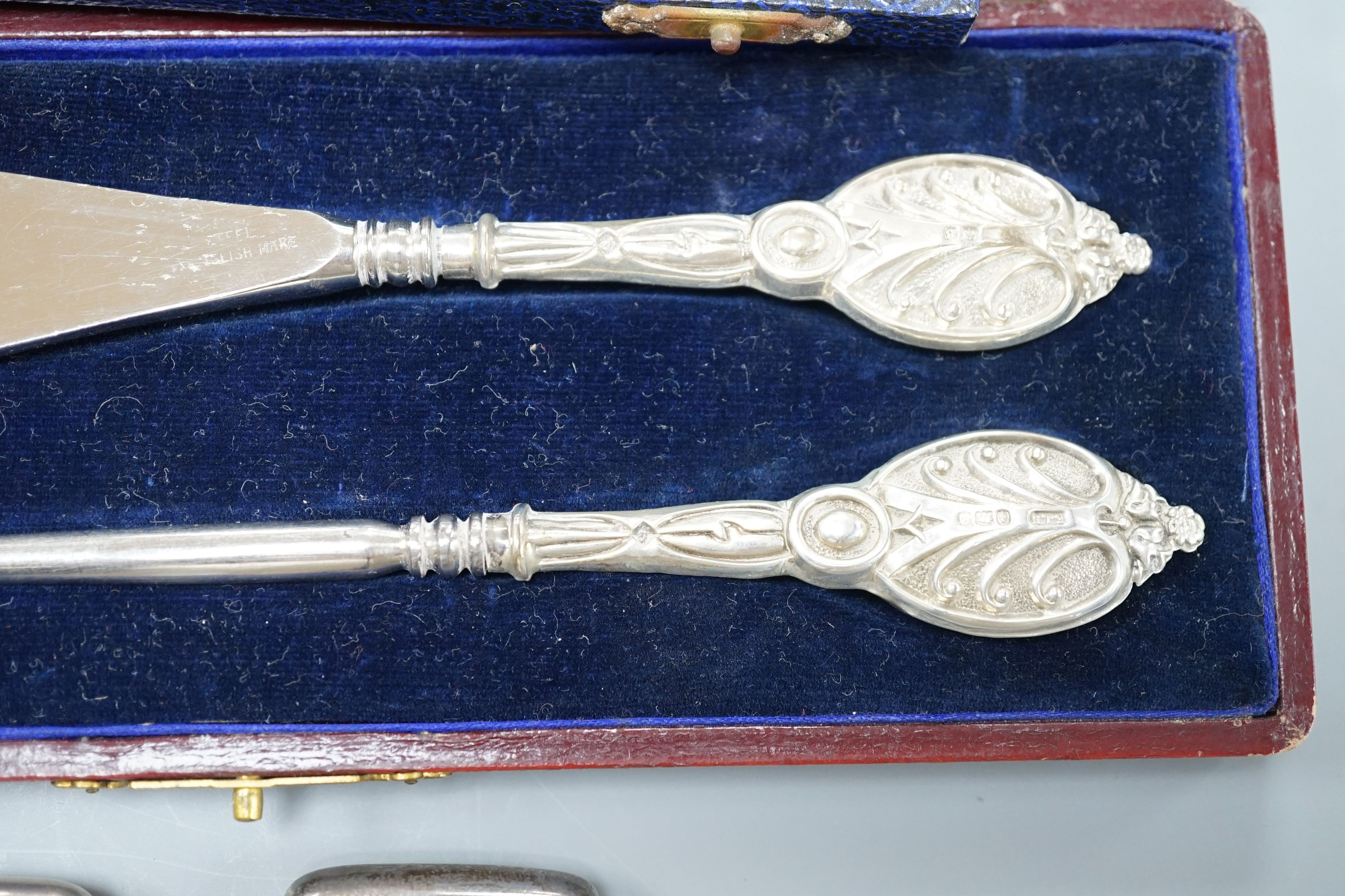 A group of small silver to include two vesta cases, a hand mirror, paste pin and a cased button hook and shoehorn.